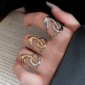 Detailed view of irregular starfish metallic rings styled on hands with books