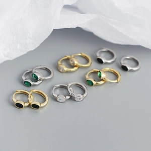 Macro shot of minimalist S925 silver ear hoops featuring colorful zircon stones in gold and silver