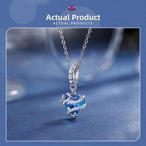 Macro del ciondolo a cuore in cristallo blu con nastro d'argento e catena a maglia O