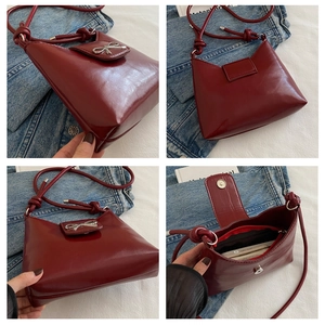 Detail view of burgundy patent leather bag with silver bow and interior pocket