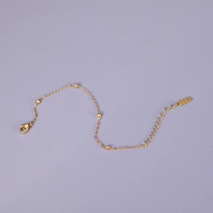 Minimalist 18K gold beaded chain bracelet featuring polished metal spheres and lobster clasp