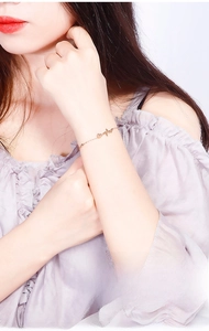 Close-up of rose gold heartbeat and heart bracelet worn on wrist with O-chain detail