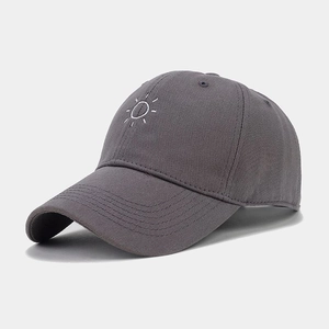 Close-up of minimalist sun embroidery on dark grey soft top baseball cap fabric