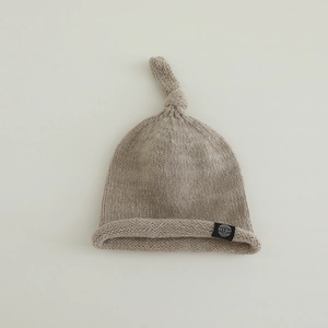 Gros plan détaillé du bonnet en tricot pour bébé avec nœud et bordure roulée