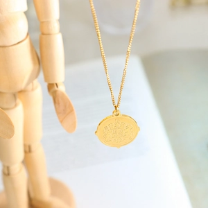 Collier vintage en or avec pendentif porte-bonheur sur un mannequin en bois élégant