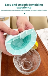 Close-up of squeezing a mint green silicone ice bucket to release small ice cubes easily