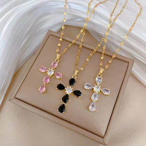 Titanium cross necklaces with colorful zircon stones on elegant beige jewelry box