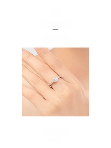 Macro detail of a six-prong silver engagement ring with sparkling pavé set diamonds