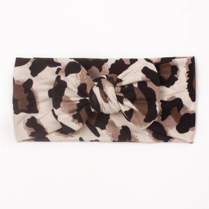 Leopard print wide baby headband with soft knot bow detail on a plain white background