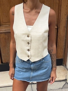 Beige cotton linen V-neck button-down vest for women shown in a street style shot