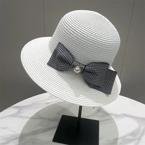 White woven straw sun hat featuring a black houndstooth bow with a pearl accent