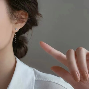 Eleganti orecchini a stella in argento s925 con catena a onde indossati sul modello