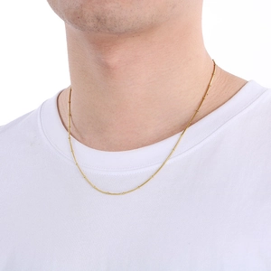 Close-up of elegant gold snake chain necklace worn on neck over a white t-shirt