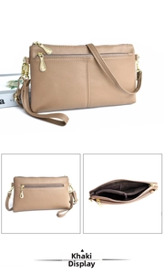 Detail view of khaki crossbody bag showing multiple zipper compartments and pebble grain texture