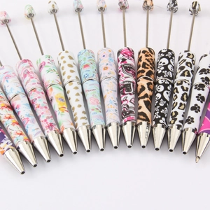 Assorted DIY beadable pens with floral, leopard, and heart prints on white background