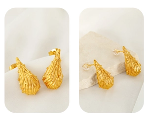 Detailed macro view of gold-plated titanium steel earrings with water-drop ripple texture