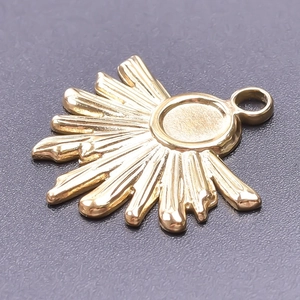 Macro shot of 18k gold plated stainless steel sun pendant showing polished sunburst details