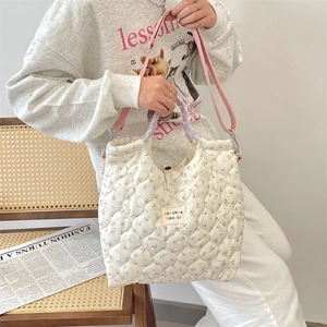 Sac à main matelassé à fleurs avec bandoulière rose et poignées à carreaux sur modèle