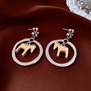 Silver flower and golden pony cutout round earrings in modern vintage metallic style