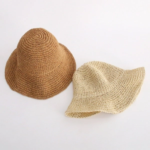 Detail of woven straw texture on tan and cream summer sun hats for women
