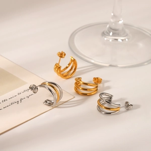 Detailed view of layered 18k gold-plated and silver stainless steel triple hoop earrings