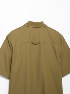 Detail view of the olive green shirt back featuring a yoke structure and central hanging loop