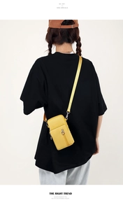 Back view of a yellow mini crossbody phone bag on model with fabric strap detail