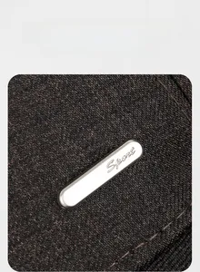 Détail macro du tissu tressé marron foncé avec plaque logo en métal argenté Sport