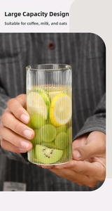 Detalle de vaso de cristal con rayas verticales lleno de rodajas de fruta y zumo