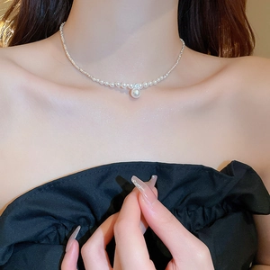 Detailed view of elegant silver necklace with pearls and high luster pendant on model