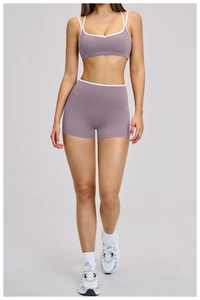 Dettaglio del set yoga lavanda con bordino bianco a contrasto su reggiseno sportivo e pantaloncini