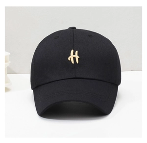 Close-up of golden letter H embroidery on a black cotton twill baseball cap with vents