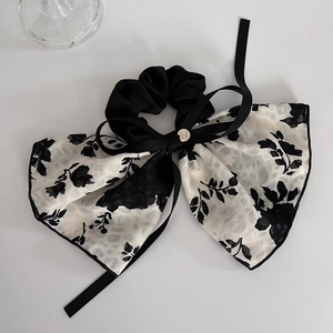 Detail of floral chiffon scrunchie with long ribbon and small metallic charm pendant