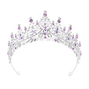 Close-up of silver crown with purple and clear rhinestones on white background