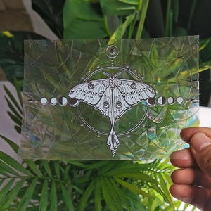 Detail of moth and moon phase rainbow prism suncatcher sticker with holographic film effect