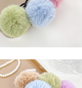 Detail view of plush colorful pompom hair ties with soft texture and vibrant pastel tones
