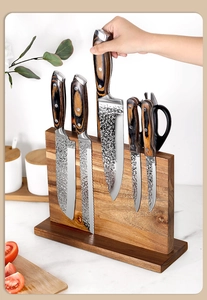 Action shot of a hand removing a hammered stainless steel knife from a magnetic wood block
