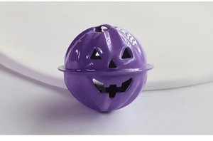 Dettaglio del campanello a zucca viola in metallo per Halloween con viso intagliato