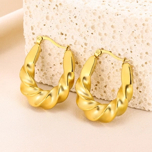Macro shot of 18K gold twisted hoop earrings with elegant spiral texture design