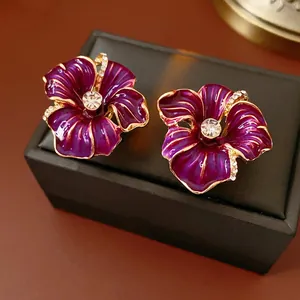 Vintage purple flower earrings with gold edges and crystal accents on black box