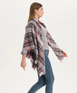 Detail of pink plaid scarf with fringe tassels on model in a professional studio setting