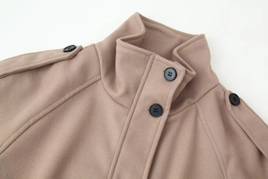 Detail of khaki wool jacket featuring a stand collar and textured fabric with black buttons