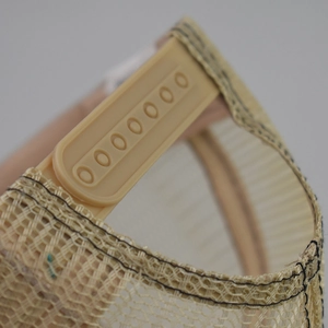 Detail of adjustable snapback closure and breathable mesh on khaki US flag trucker hat
