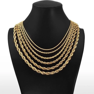 Detail of layered gold twisted rope chain necklaces on a black jewelry mannequin stand