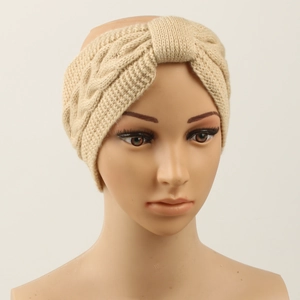Detail of beige cable knit headband showing thick textured weave and front twist knot