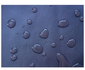 Dettaglio ravvicinato di pelle PU impermeabile blu scuro con goccioline d'acqua chiare