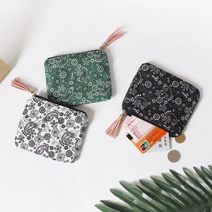 Mini paisley coin purses in green, white, and black with fringe zippers on white background