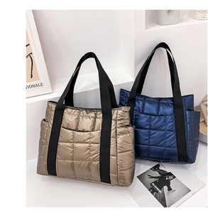 Detailed close-up of quilted metallic gold and navy tote bags with side pockets