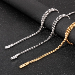Detailed view of 6mm square box chains in silver and 18k gold finishes on dark background