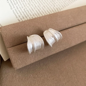 Detailed close-up showing the brushed silver texture of round minimalist stud earrings